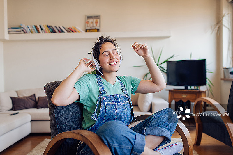 女孩在客厅唱歌，享受音乐图片素材