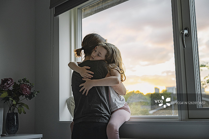 小女孩依偎在母亲怀里图片素材