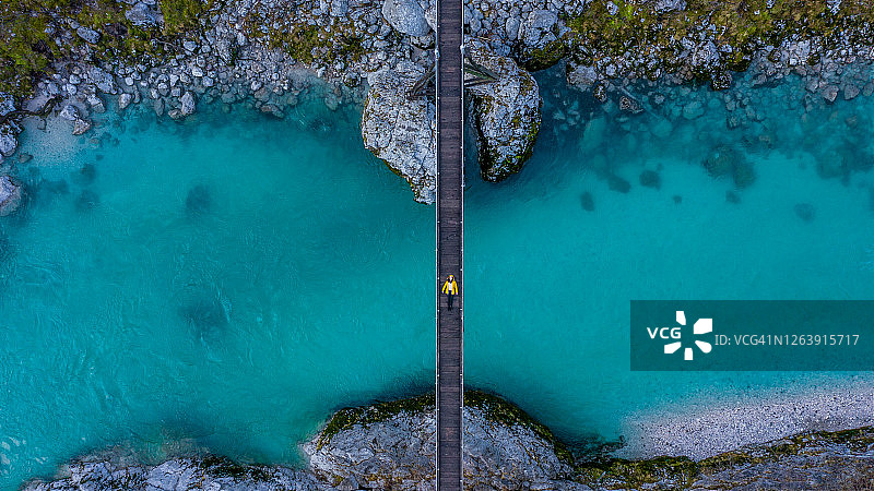 悬索桥上的俯视图，年轻女子躺在桥上图片素材