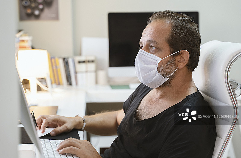 戴着防护口罩在办公室工作的商人图片素材