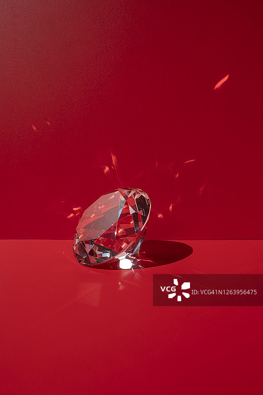 红色背景上的一颗闪亮钻石图片素材