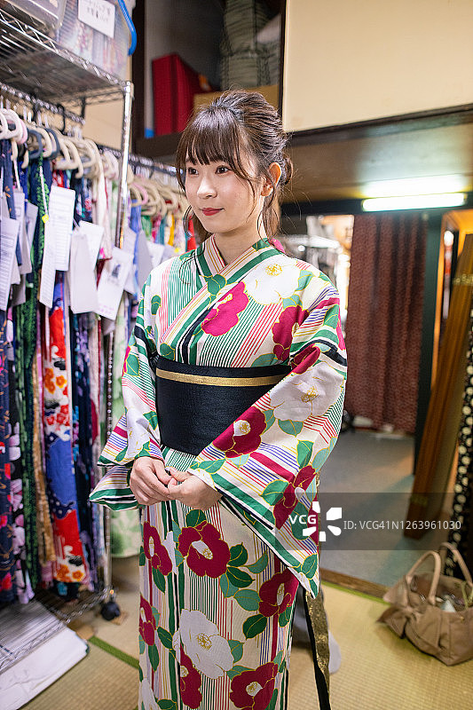 年轻女子身穿浴衣站在试衣间里图片素材