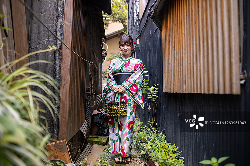 身穿浴衣参观日本古村落的年轻女人肖像图片素材