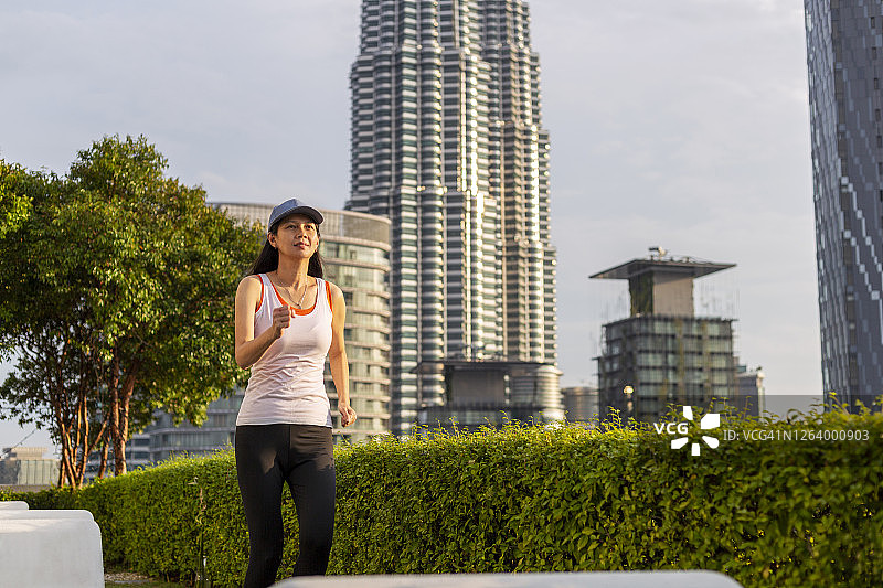 亚洲美女在日出时分的城市公园慢跑图片素材