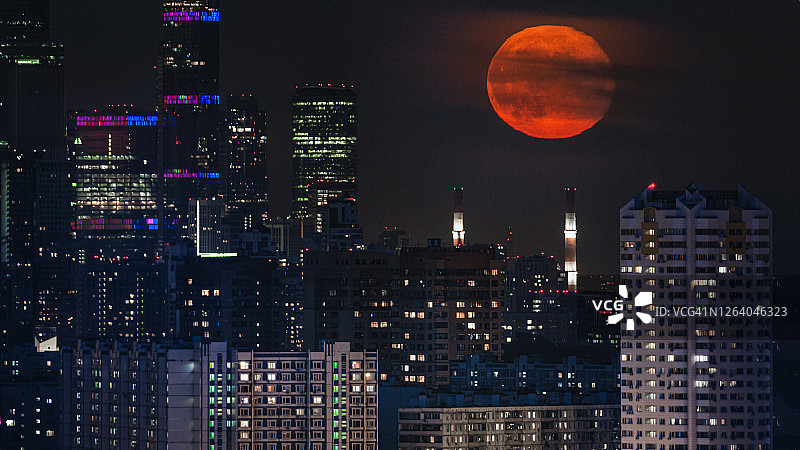 红色满月下的夜晚大都市城市景观图片素材