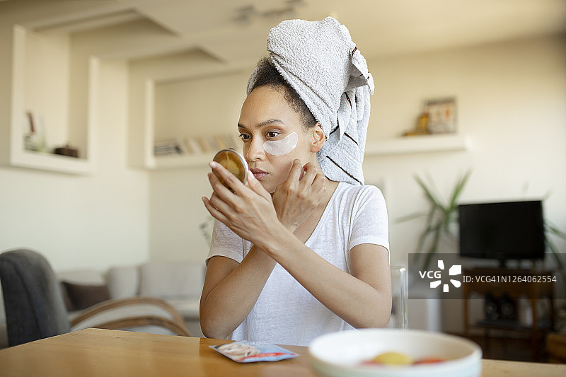 年轻的非裔美国女性在脸上化妆图片素材
