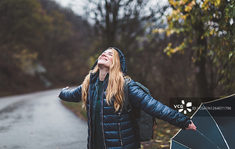 快乐的女人在雨中行走图片素材