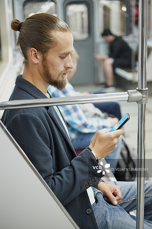 中年白人男子在地铁中使用智能手机图片素材