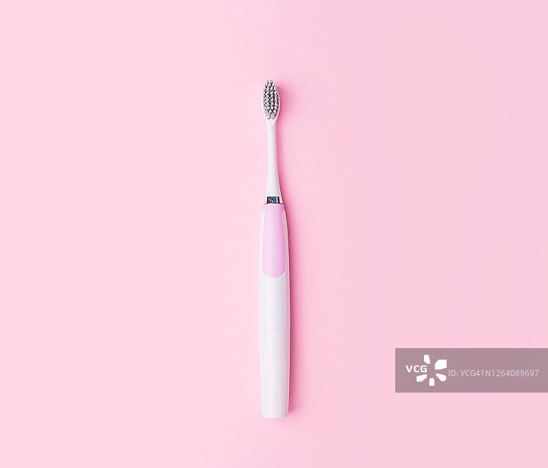 粉色背景上的电动牙刷留有文字空间单亲家庭概念图片素材
