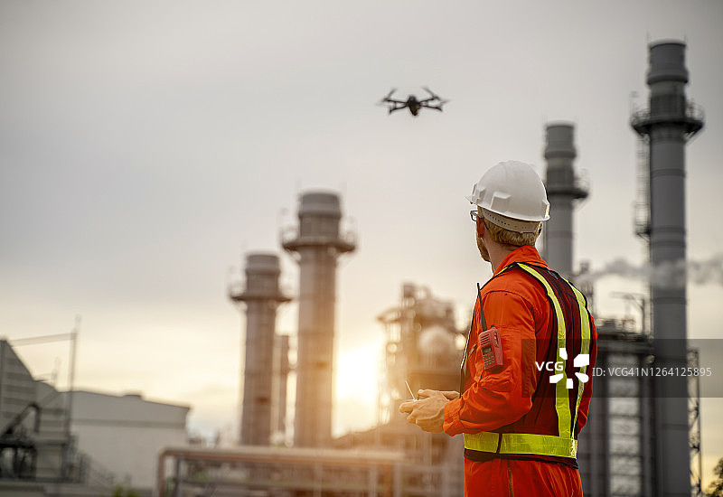 年轻工程师在建筑工地操控无人机，视频监控或工业检测图片素材
