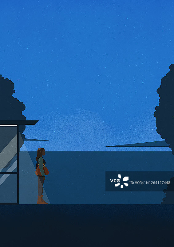 年轻女子在夜晚黑暗的巴士站等车图片素材