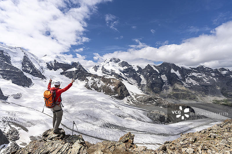 男子在瑞士迪亚沃莱扎冰川的皮兹特罗瓦特山顶欣赏风景图片素材