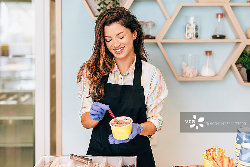 冰淇淋店里快乐的棕发女店员图片素材