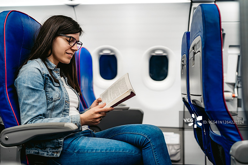女人在飞机上阅读图片素材