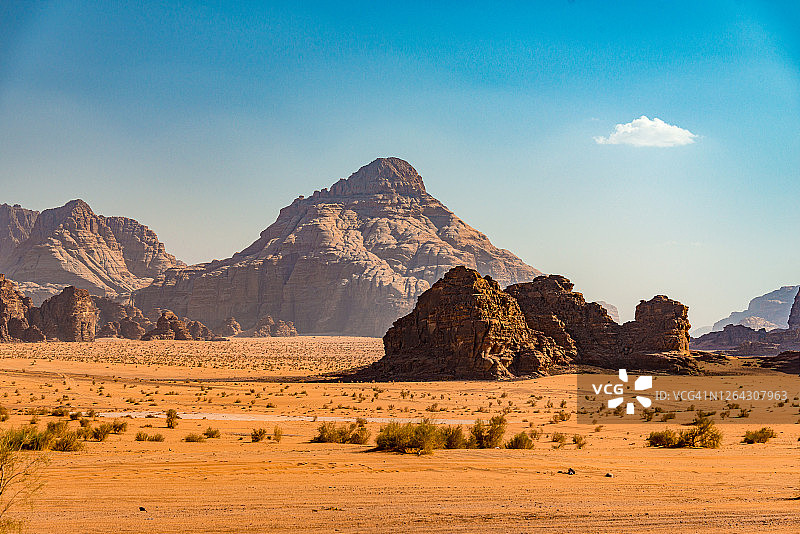约旦瓦迪拉姆沙漠塔岩层和绿色植物图片素材