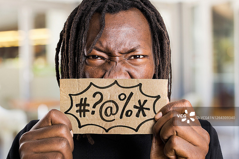 愤怒的男人举着带有咒骂符号的牌子图片素材