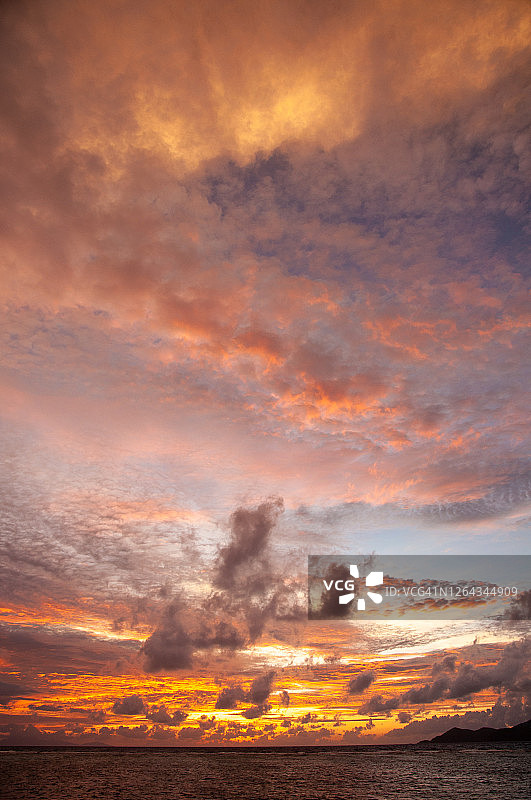充满活力的暖色调热带日落与岛屿轮廓图片素材
