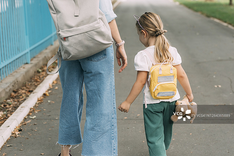 开学季：母亲送可爱的女儿去上学图片素材