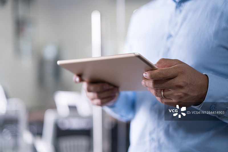 年轻男人在现代办公室使用平板电脑图片素材