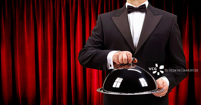 男管家手持盖着的餐盘图片素材