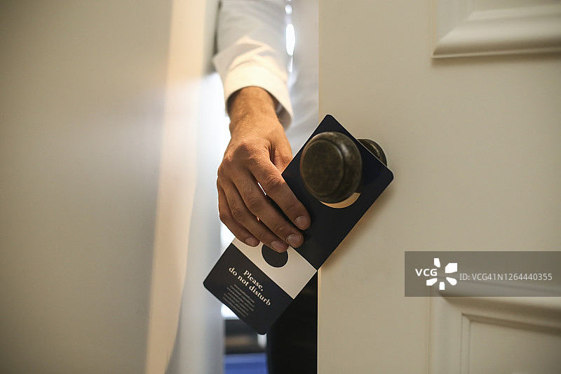 男人挂“请勿打扰”标志图片素材