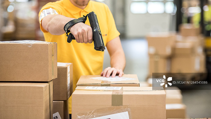 邮政工作人员使用条形码扫描器扫描包裹图片素材