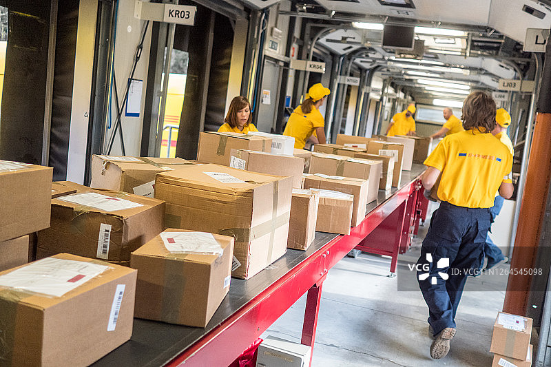 邮政工人在传送带上处理包裹图片素材