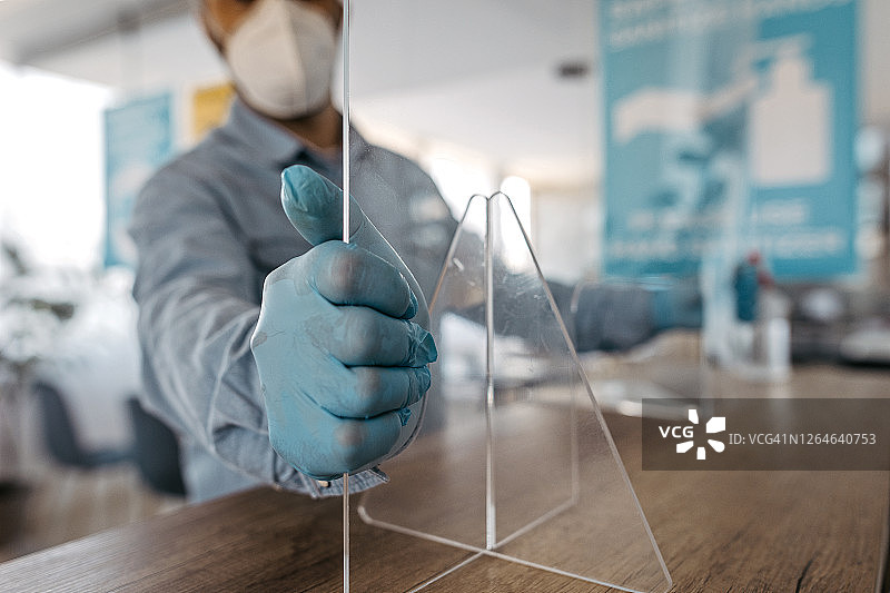 男人在办公室柜台修理亚克力玻璃图片素材