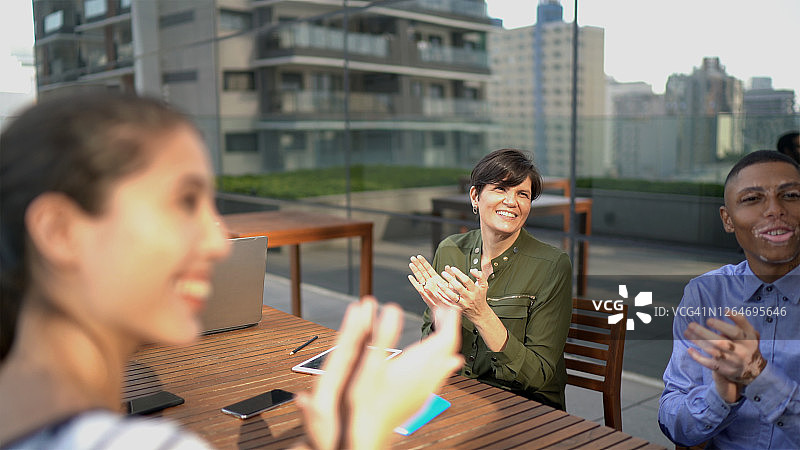 商务人士在屋顶办公室会议上鼓掌图片素材