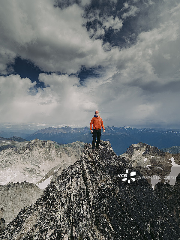 攀岩者站在布加布冰川省立公园新月塔的小山顶上，头顶是引人注目的天空图片素材
