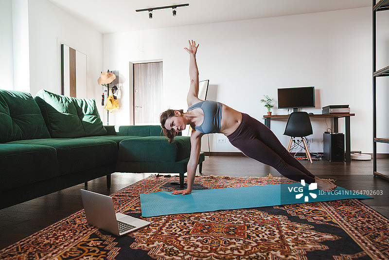 女人在家与在线老师一起做侧平板支撑图片素材