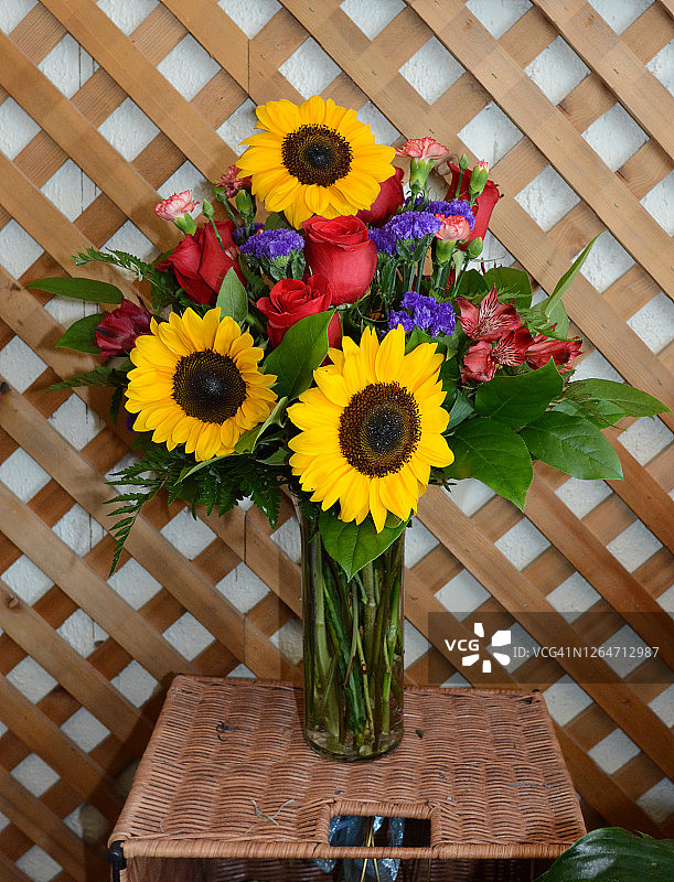 向日葵、玫瑰和其他鲜花的花瓶图片素材