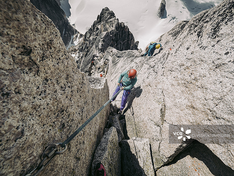 攀岩者沿陡峭的布加布山峰绳降图片素材