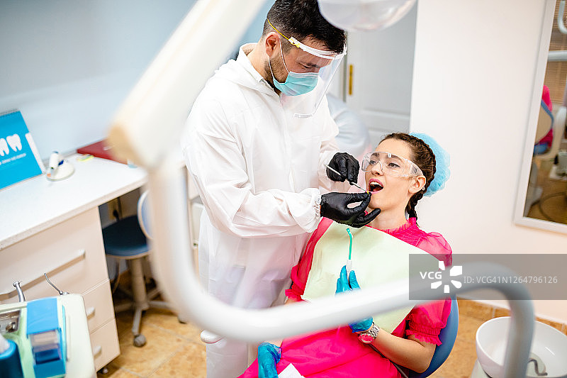 牙医使用根管针收集牙齿上的细菌菌落进行研究图片素材