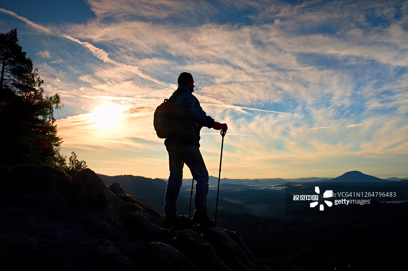 手持杆子的游客轮廓。带有运动背包的徒步旅行者站立。阳光明媚的春日图片素材