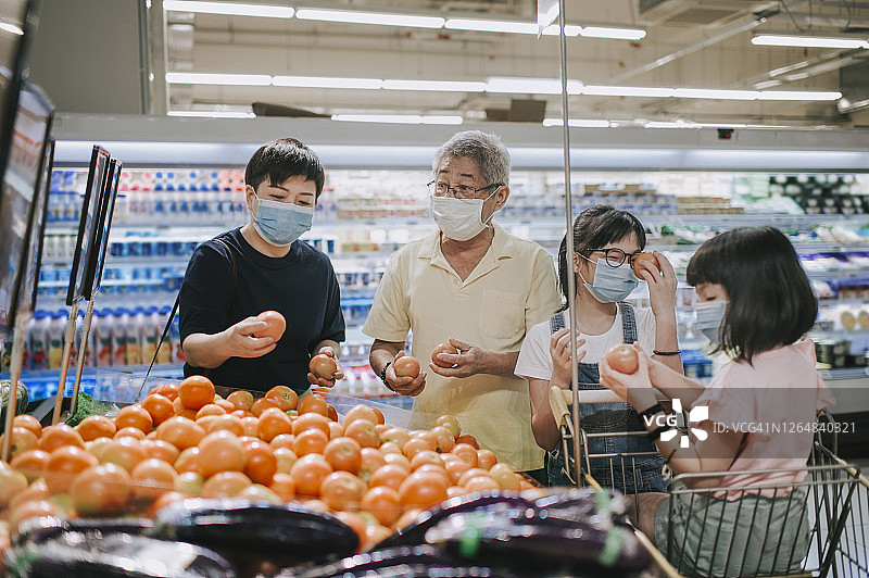 中国中年女性与家人在超市购买番茄图片素材