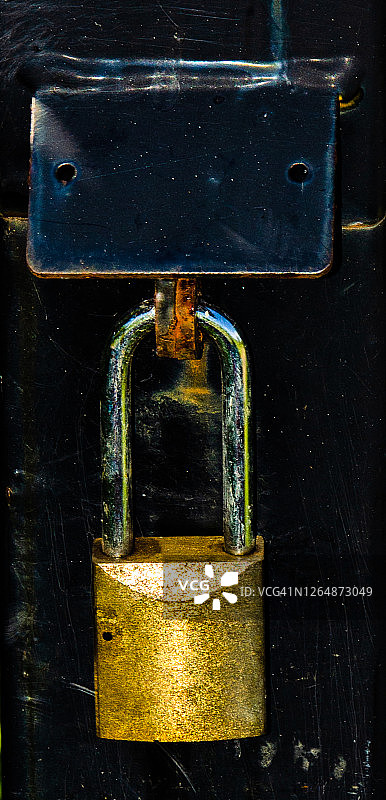 黑色柱子上一个生锈的挂锁图片素材