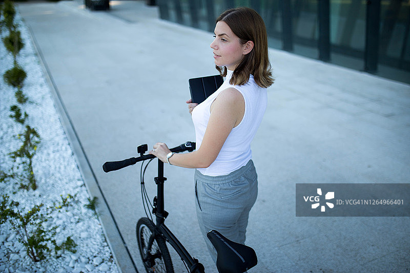 骑着折叠自行车上班的商务女人图片素材