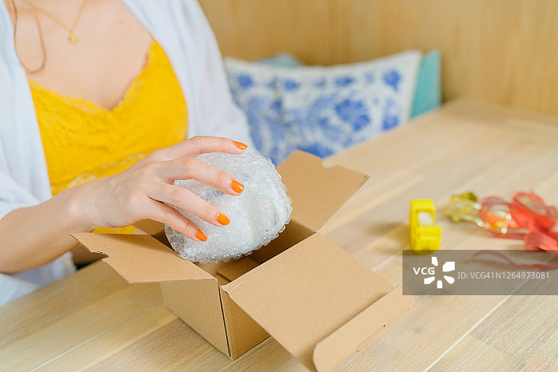 年轻女子在家准备礼品盒的特写照片图片素材