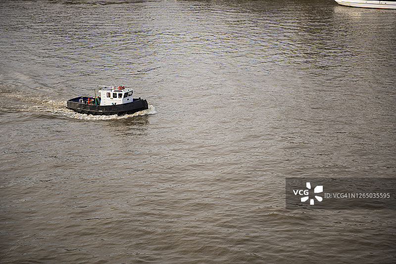 在伦敦泰晤士河上巡航的拖船图片素材