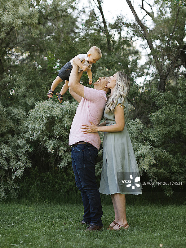 幸福的父母在花园里和儿子玩耍图片素材