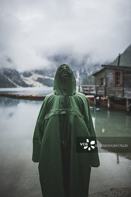 意大利：站在布莱斯湖（Pragser Wildsee）的穿雨衣的男人图片素材