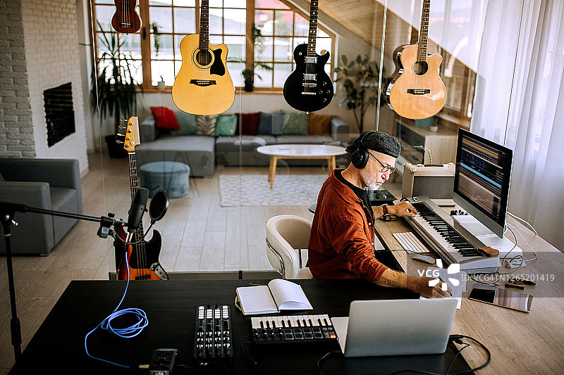 年长的音乐家在他的家庭办公室工作室写作图片素材
