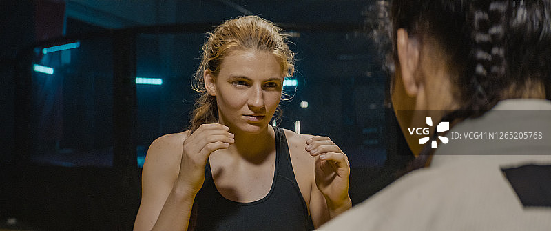 女子综合格斗选手训练，首次出拳前的眼神交流图片素材