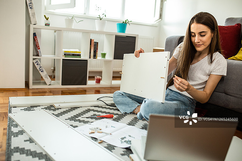 女人在家组装平板家具图片素材