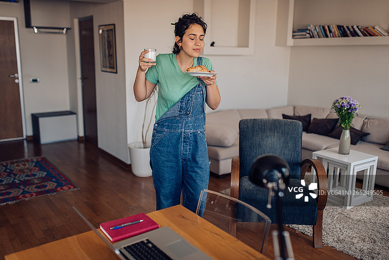 女孩端着并闻着她的早餐图片素材