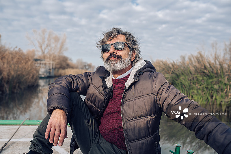 年长的男人享受河流周围的自然风光图片素材