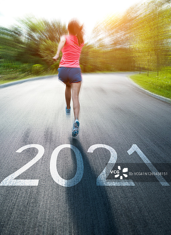 年轻的亚洲女性在公园里慢跑，地上有2021数字图片素材