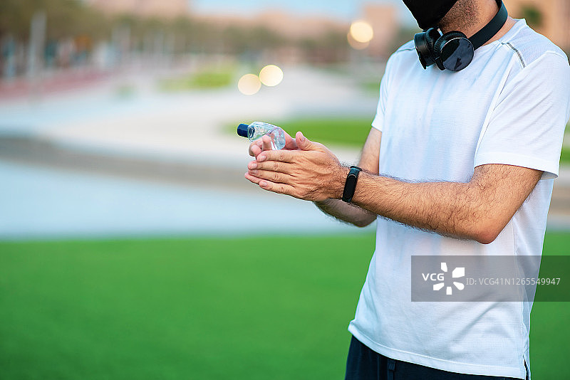 男人在户外锻炼后使用洗手液或抗菌皂洗手图片素材