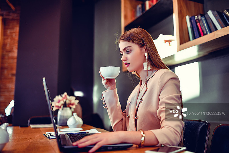 在办公室喝茶工作的女企业主图片素材